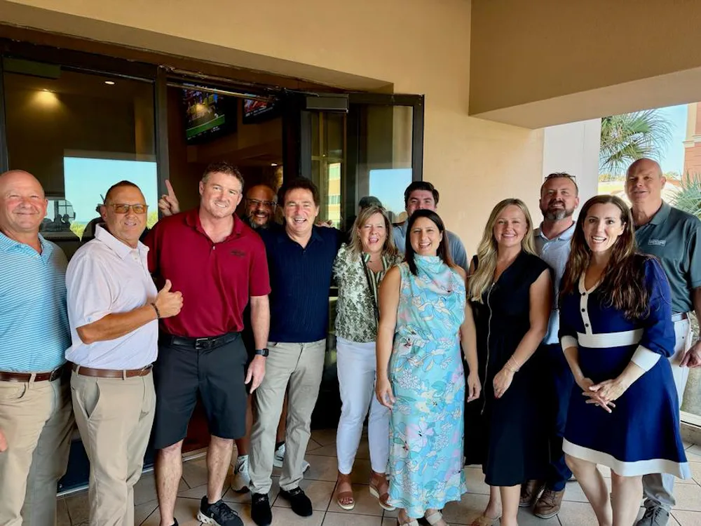 Cassie in Turquoise dress in the middle, with many of her Chesapeake Homes sales team 
